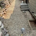 Gravel and rock landscaping installation alongside a Spearfish, South Dakota home completed by South Dakota Services, featuring newly laid decorative stone and retaining wall.