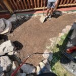 South Dakota Services crew performing dirt work and plant removal for landscaping preparation in Spearfish, SD, with soil grading near a residential home.