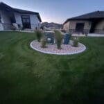 Evening view of freshly mowed residential lawn in Spearfish, South Dakota maintained by South Dakota Services with clean edging around landscaped rock bed.