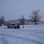 Snow removal truck clearing snow from a commercial parking lot in Spearfish, SD as part of professional snow removal services by South Dakota Services.