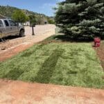 Professional sod installation by South Dakota Services in Spearfish, SD featuring freshly delivered sod being installed on a residential front lawn in the Black Hills.